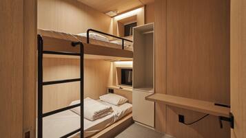 A bunk bed room with a desk and a mirror.