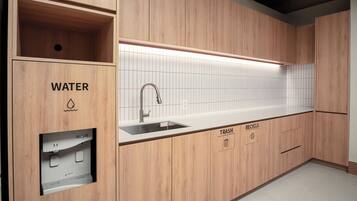 A modern kitchen with wooden cabinetry, a built-in sink, and a water dispenser.