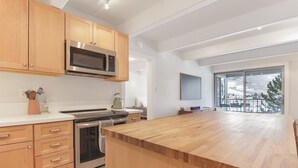 A modern kitchen with wooden cabinets, stainless steel appliances, and a large wooden island. - 317 Lodge At Lake Dillon 1 Bedroom Condo (Dillon)