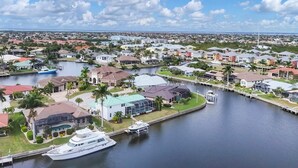 A residential area with houses, a marina, and a large yacht docked. - Punta Gorda Isles Private Pool Vacation Home - Waterfront Canal Views 4 Bedroom Home (Punta Gorda)