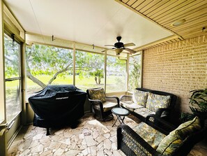 A covered patio area with a ceiling fan, outdoor seating, and a barbecue grill. - Coastal escape/pool/pickleball/pets/tennis/golf/beach & fun (Laguna Vista)