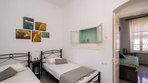 A room with two beds, a green cabinet, and artwork on the wall. - Kypseli House - Quiet Garden Home for Families & Groups, steps from Apollonia (Apollonia)
