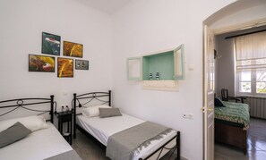 A room with two beds, a green cabinet, and artwork on the wall. - Kypseli House - Quiet Garden Home for Families & Groups, steps from Apollonia (Apollonia)