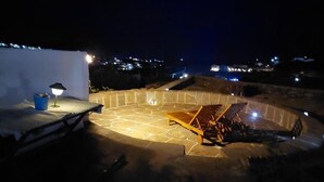 A rooftop terrace with a stone floor, a small table with a lamp, and a lounge chair. - Kypseli House - Quiet Garden Home for Families & Groups, steps from Apollonia (Apollonia)
