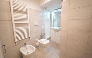 A bathroom with a white sink, toilet, and towel rack. - Residenza Bernini (Rome)