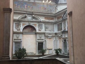 An interior courtyard with classical architecture, including columns, a central archway, and a frescoed ceiling. - Residenza Bernini (Rome)