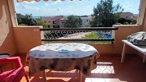 A balcony with a table and chairs, a view of the sea, and a railing. - Exceptional stay in Corsica - Air-conditioned apartment with sea view in Bravone (Linguizzetta)