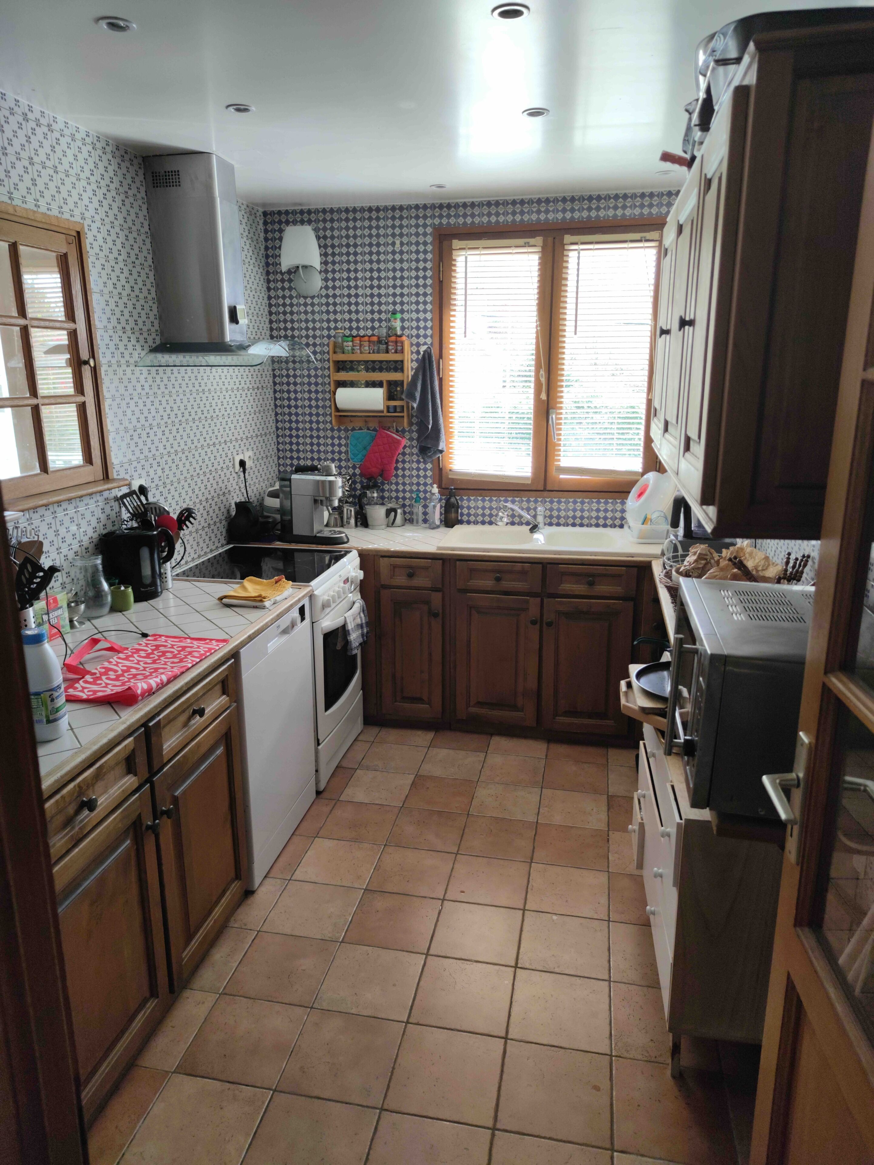 Una cocina con estufa, horno, lavamanos y armarios.