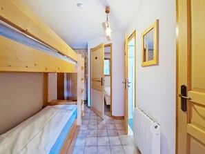 A narrow hallway with bunk beds on one side and a door leading to a bathroom on the other. - Forsythia FA14 FAMILY & NATURE 5 people (Châtel)