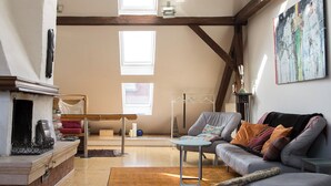 A loft-style living room with high ceilings, exposed beams, and skylights. - Central Penthouse, for romantic lovers and those who love to read and chill (Graz)
