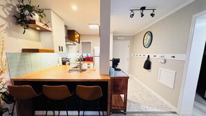 A modern kitchen with a central island, bar stools, a microwave, and a coffee machine. - Oceanfront condo - walk to the beach 10min or use free shuttle (Hilton Head Island)