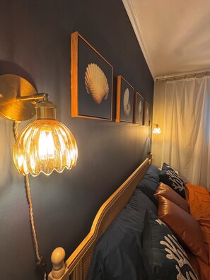 A bedroom with a bed, a wall-mounted lamp, and framed artwork. - Oceanfront condo - walk to the beach 10min or use free shuttle (Hilton Head Island)