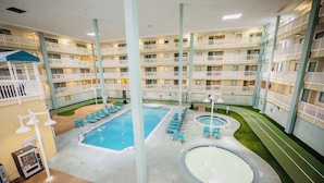 A multi-level hotel with a central pool area, multiple balconies, and a vending machine. - Oceanfront condo - walk to the beach 10min or use free shuttle (Hilton Head Island)