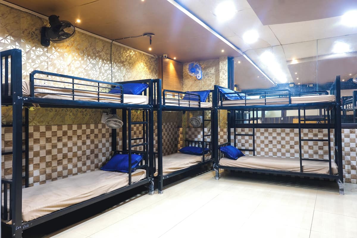 A room with bunk beds, patterned wallpaper, and ceiling fans.