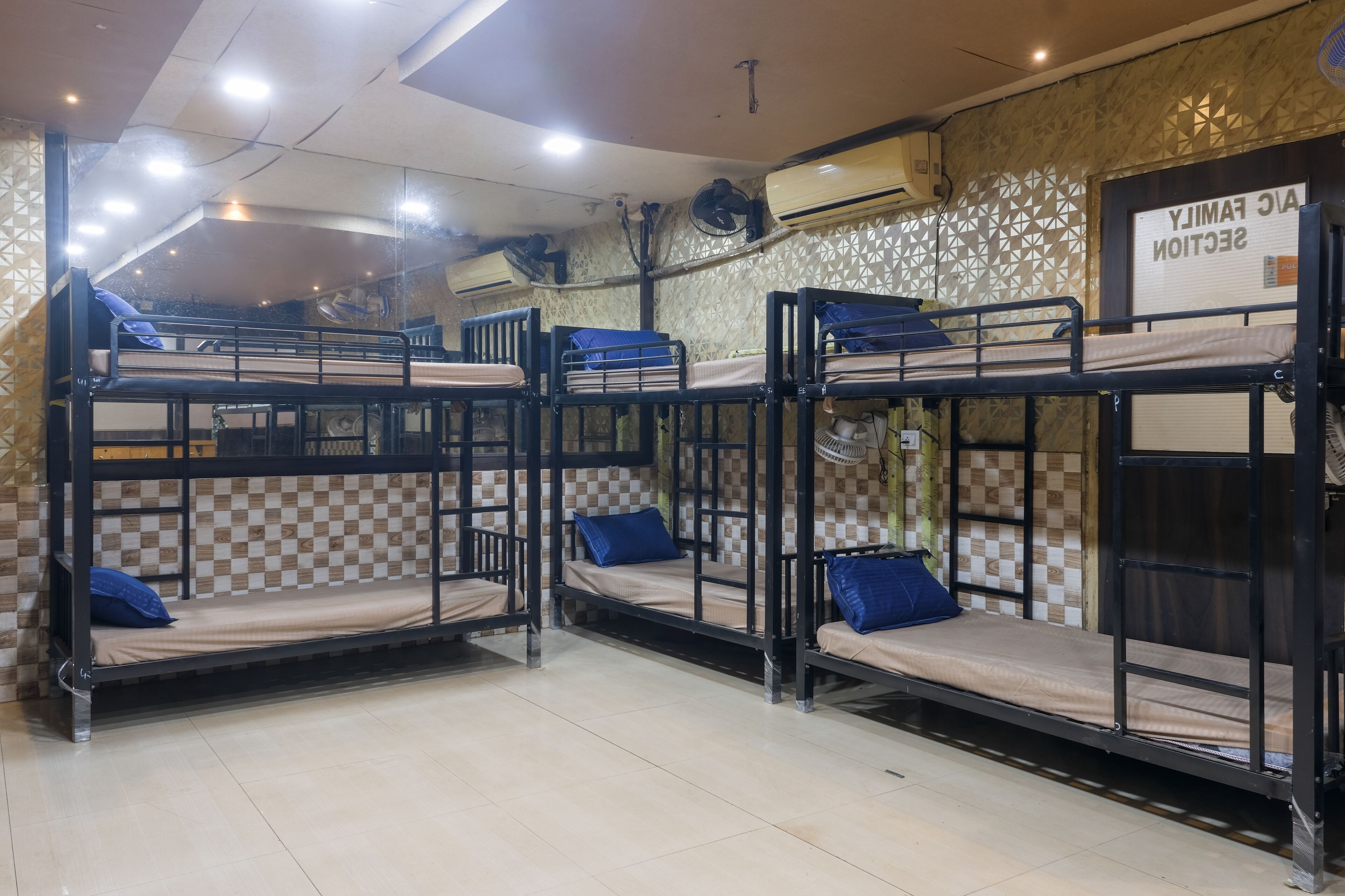 Un dormitorio con literas, unidades de aire acondicionado y una pared con diseño.