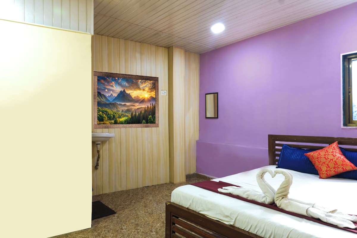 A hotel room with a bed, a painting of a landscape, a wooden wall, and a purple wall.