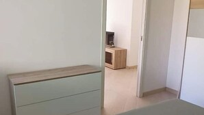 A bedroom with a bed, a dresser, and a TV stand in the background. - Cozy ground-floor mini apartment a few meters from Rimini's dockyard (Rimini)