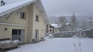 A two-story house with a snow-covered roof and yard. - Large family home in Annecy 6 bedrooms 12 people 15 minutes from the lake! (Annecy)