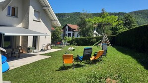 A house with a patio, outdoor seating, and a view of a hill. - Large family home in Annecy 6 bedrooms 12 people 15 minutes from the lake! (Annecy)