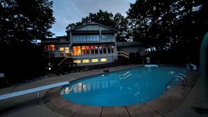 Una piscina con una casa al fondo.