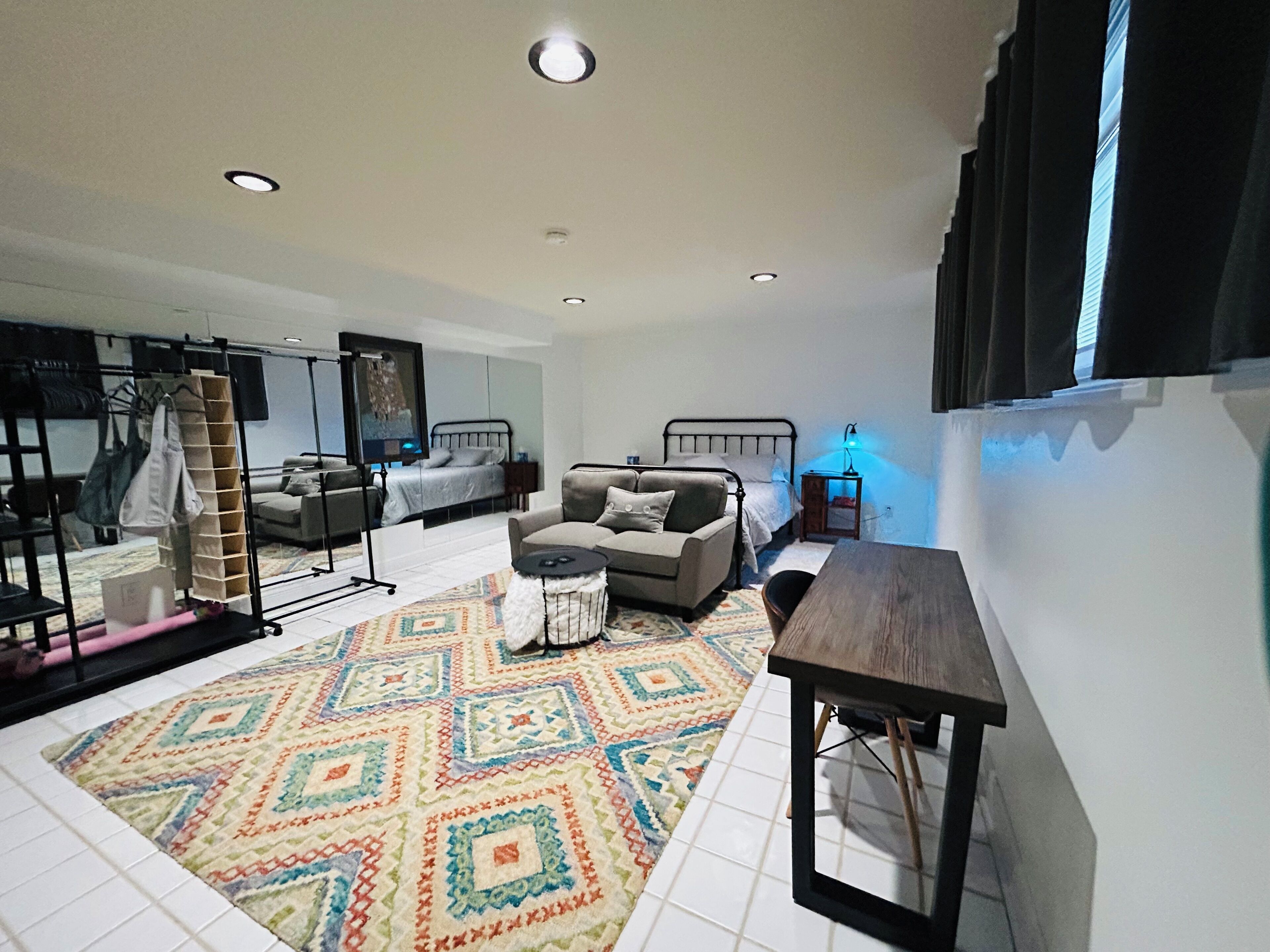 Una sala de estar moderna con un sofá, una mesa de centro, un televisor y una alfombra estampada.