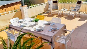 An outdoor patio with a table set for dining, surrounded by chairs and a small table with a plant. - Spacious and bright with large terrace. Ságaró (Costa Brava) (El Vilar d'Aro)