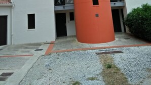 Un immeuble à plusieurs étages, caractérisé par une structure cylindrique orange distinctive située au centre.
