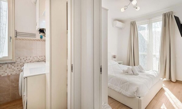 A bedroom with a bed, curtains, and a window. - Beautiful holiday home in Riccò del Golfo, in a terraced house, in the province of La Spezia, just 15 minutes by car from the centre of La Spezia. The house is ideal for those seeking tranquility and nature, but with the convenience of being close to th (Riccò del Golfo)