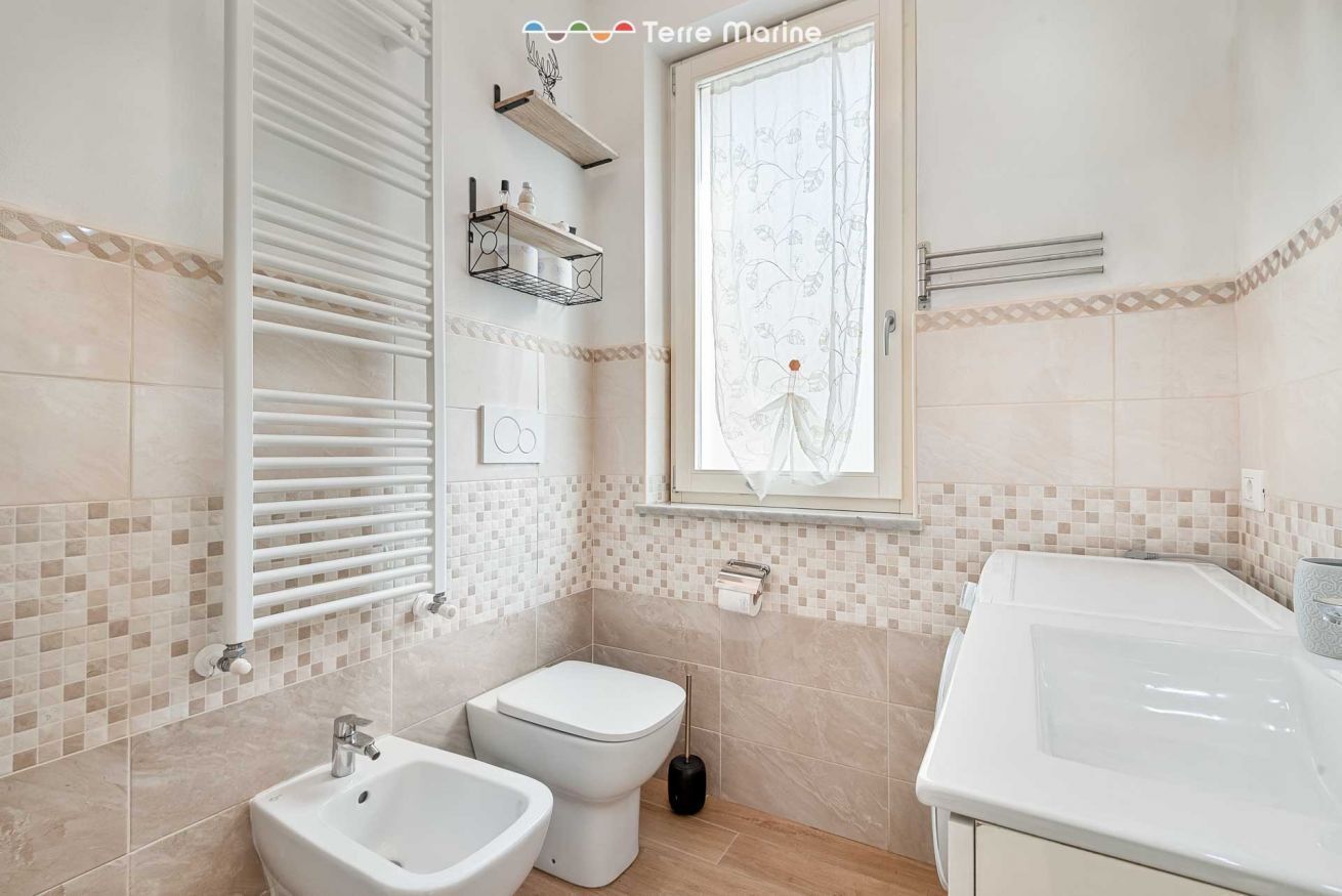 Een douche, een bidet, handdoeken, toiletpapier