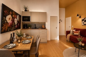 Eine moderne Küche mit Essbereich, einem roten Sofa und einem Bild an der Wand.