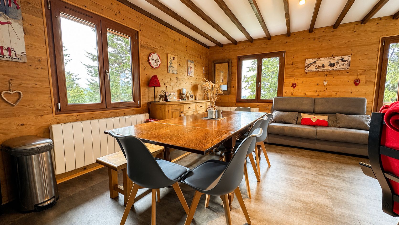 Ein Holzinterieur mit Esstisch, Stühlen, einer Couch und einer Heizung.