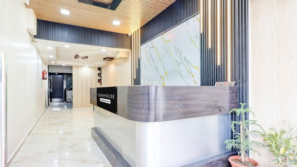 A reception desk with a marble floor, a wooden ceiling, and potted plants. - Townhouse Jabalpur View Point (Jabalpur)