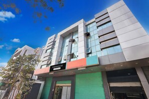 A modern building with a sign reading 'TOWNHOUSE' and a green shuttered entrance. - Classic Hotel pix (Jabalpur)