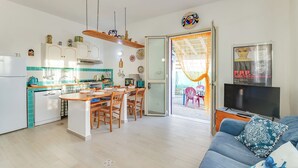 A compact living space with a kitchen, dining area, and a living room. - Montalbano House by Biddizzi Rari - Direct access to the beach, beach house (Località San Marco)