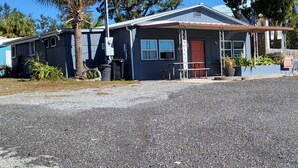 A two-story building with a porch, a red door, and a sign that reads "Welcome". - Adorable 2-bedroom house with AC in peaceful Steinhatchee (Steinhatchee)