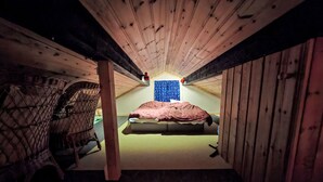 A small attic bedroom with a single bed, a chair, and a window with a blue polka dot curtain. - Gördalen by Interhome (Särna)