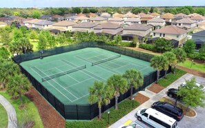 A tennis court surrounded by residential houses, with a parking area and a few vehicles. - Luxury 7BR Home w/ Pool & Spa Near Disney (Davenport)