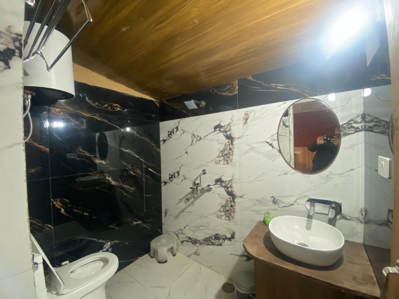 A bathroom with a toilet, sink, and mirror.