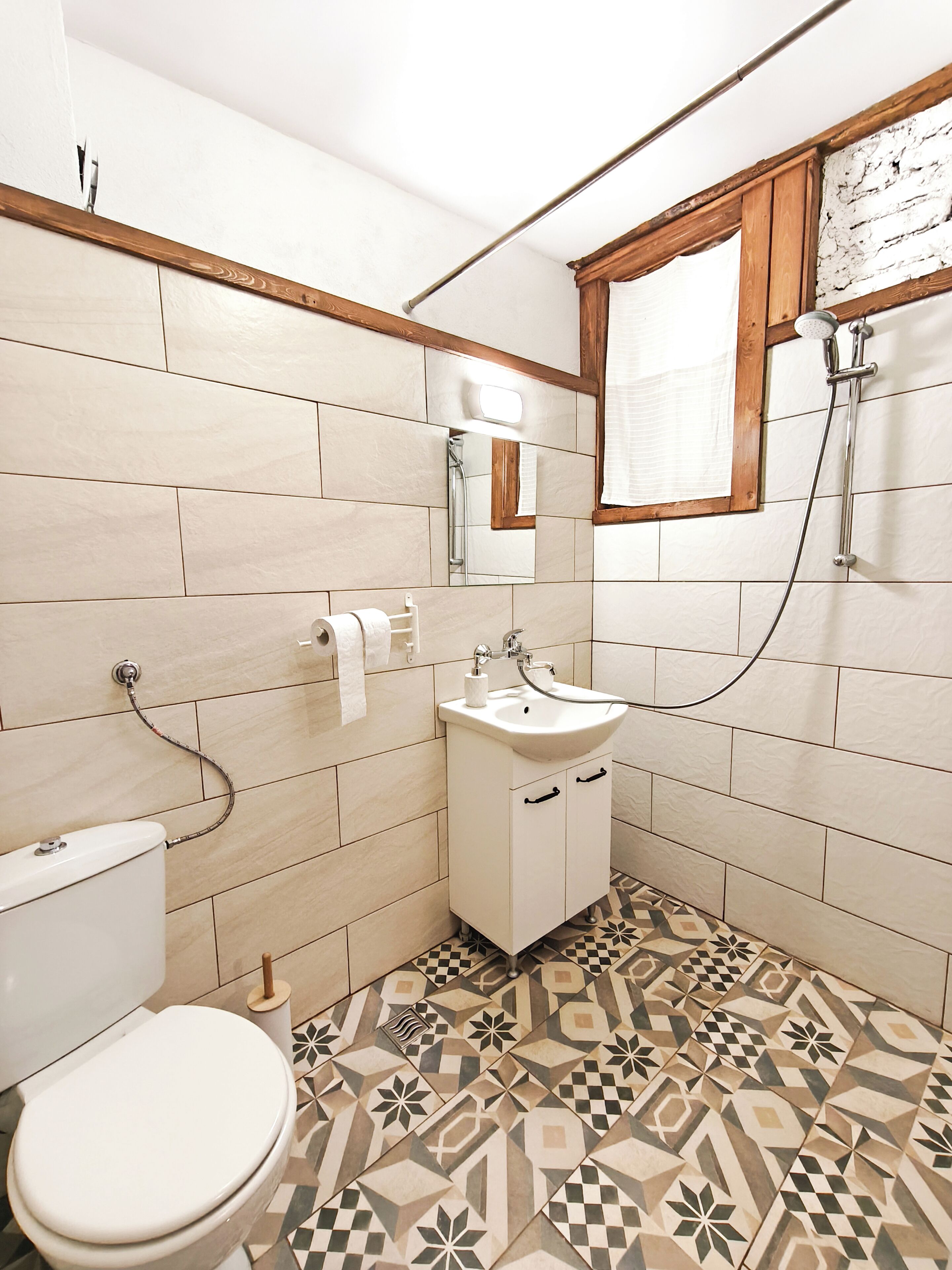 Un baño con inodoro, lavamanos y ducha.