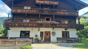 Un immeuble en bois à plusieurs étages, doté de balcons, d’une façade blanche et de jardinières.