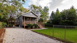 A two-story house with a porch and a fenced yard. - Pet-Friendly Home with Fenced Yard (Raleigh)