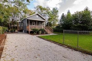 A two-story house with a porch and a fenced yard. - Pet-Friendly Home with Fenced Yard (Raleigh)