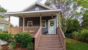 A two-story house with a covered porch and a front door. - Pet-Friendly Home with Fenced Yard (Raleigh)