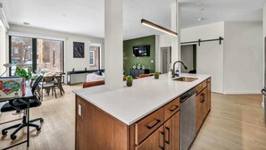 Une cuisine moderne dotée d’un grand îlot central, de meubles en bois et d’un lave-vaisselle encastré.