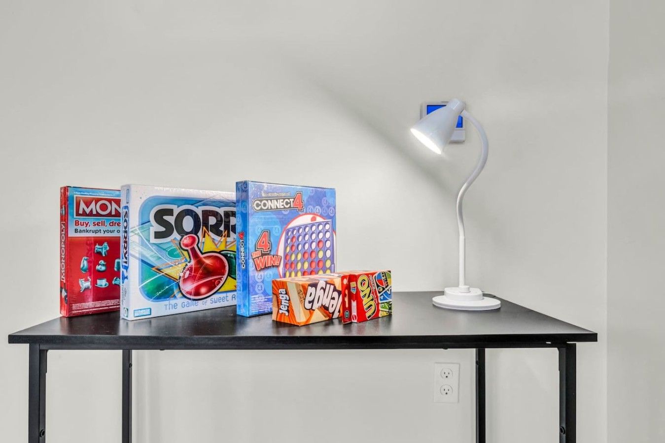 A table with board games and a desk lamp.
