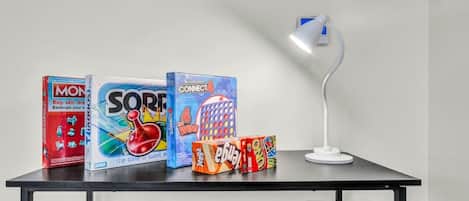 A table with board games and a desk lamp.