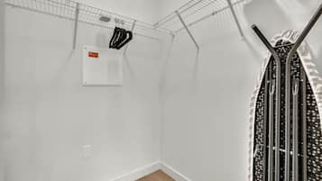 Una stanza con un muro bianco, un appendiabiti in metallo, una lavagna e una tenda decorata.