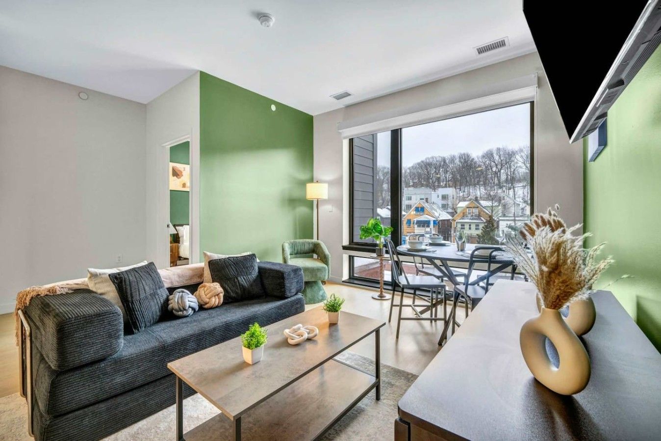 A modern living room with a sofa, coffee table, and dining area.