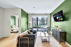Una sala moderna con sofá, mesa de centro y zona de comedor.