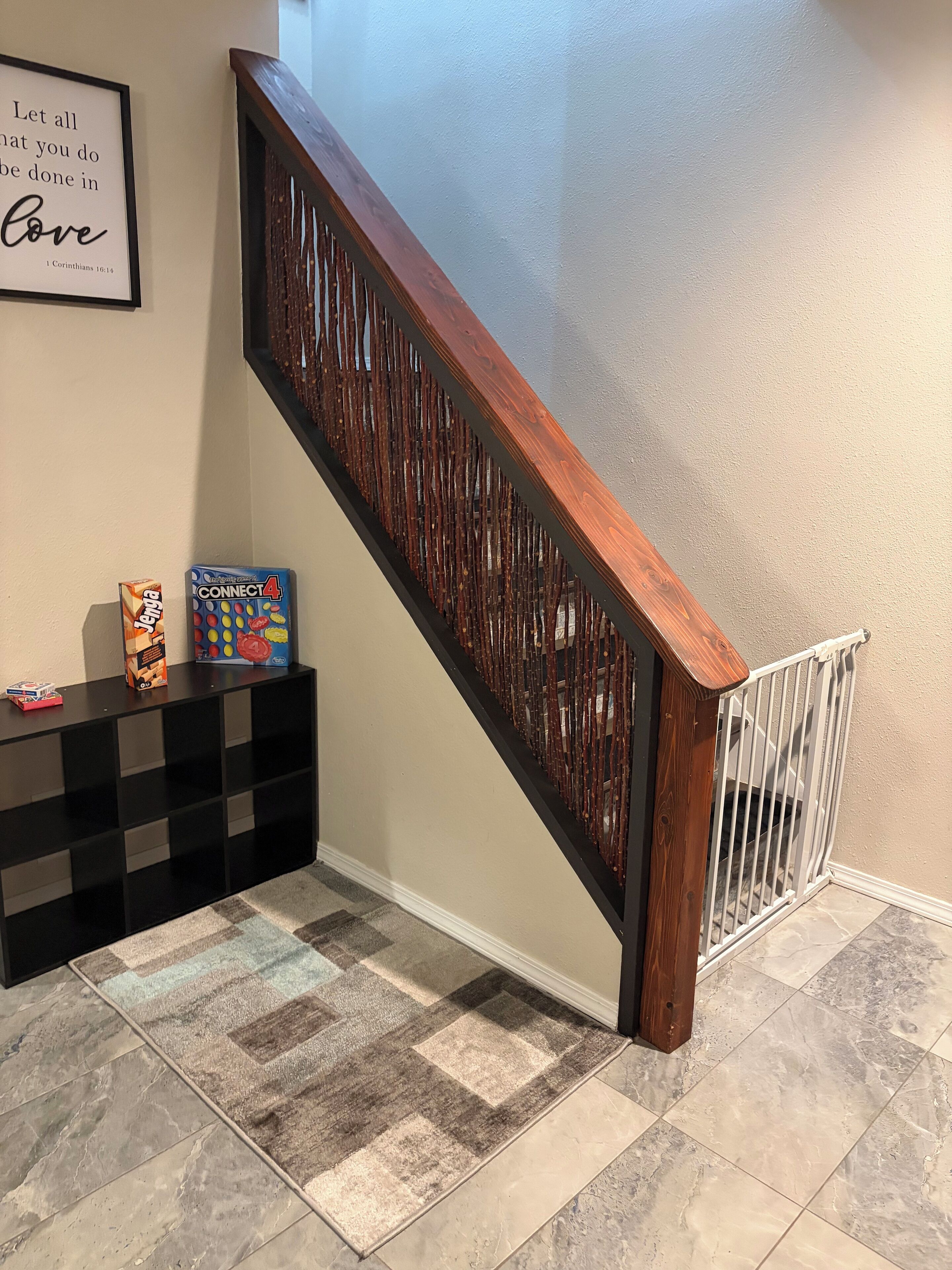 Una escalera con barandilla de madera y un panel decorativo.